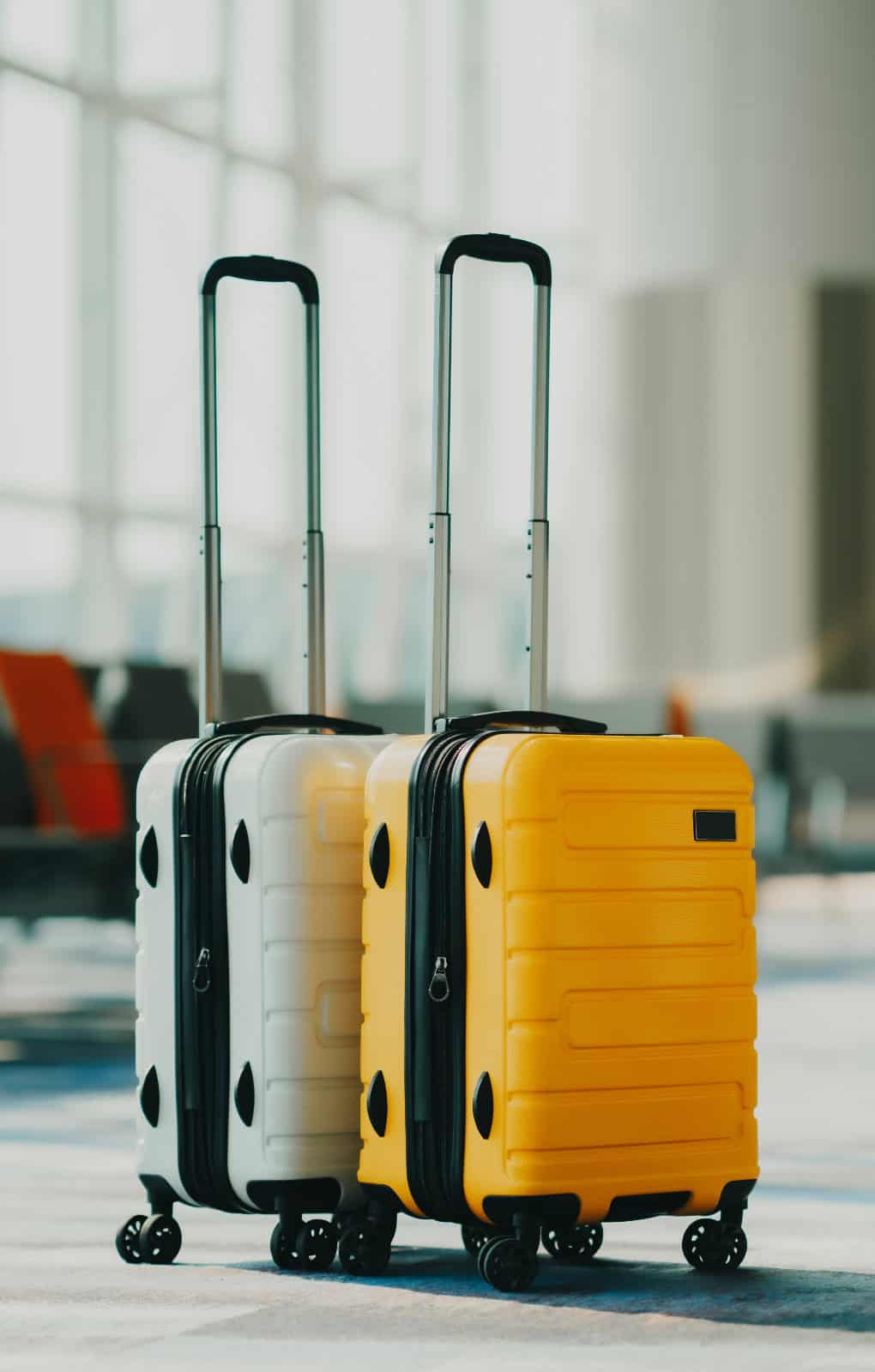 Two suitcases in an empty airport hall, traveler cases in the de